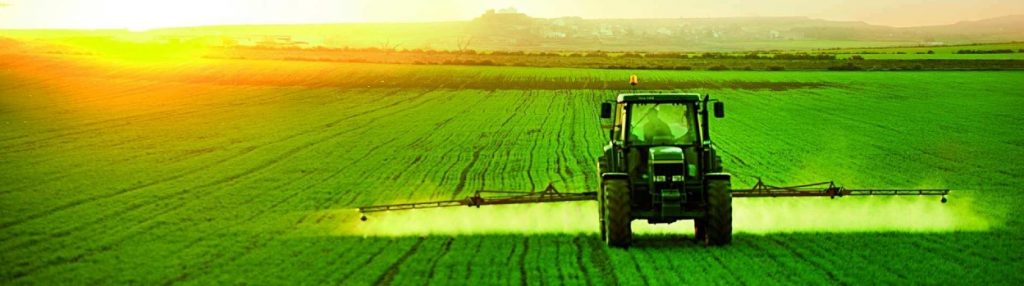 Un tractor esparciendo un líquido en un campo